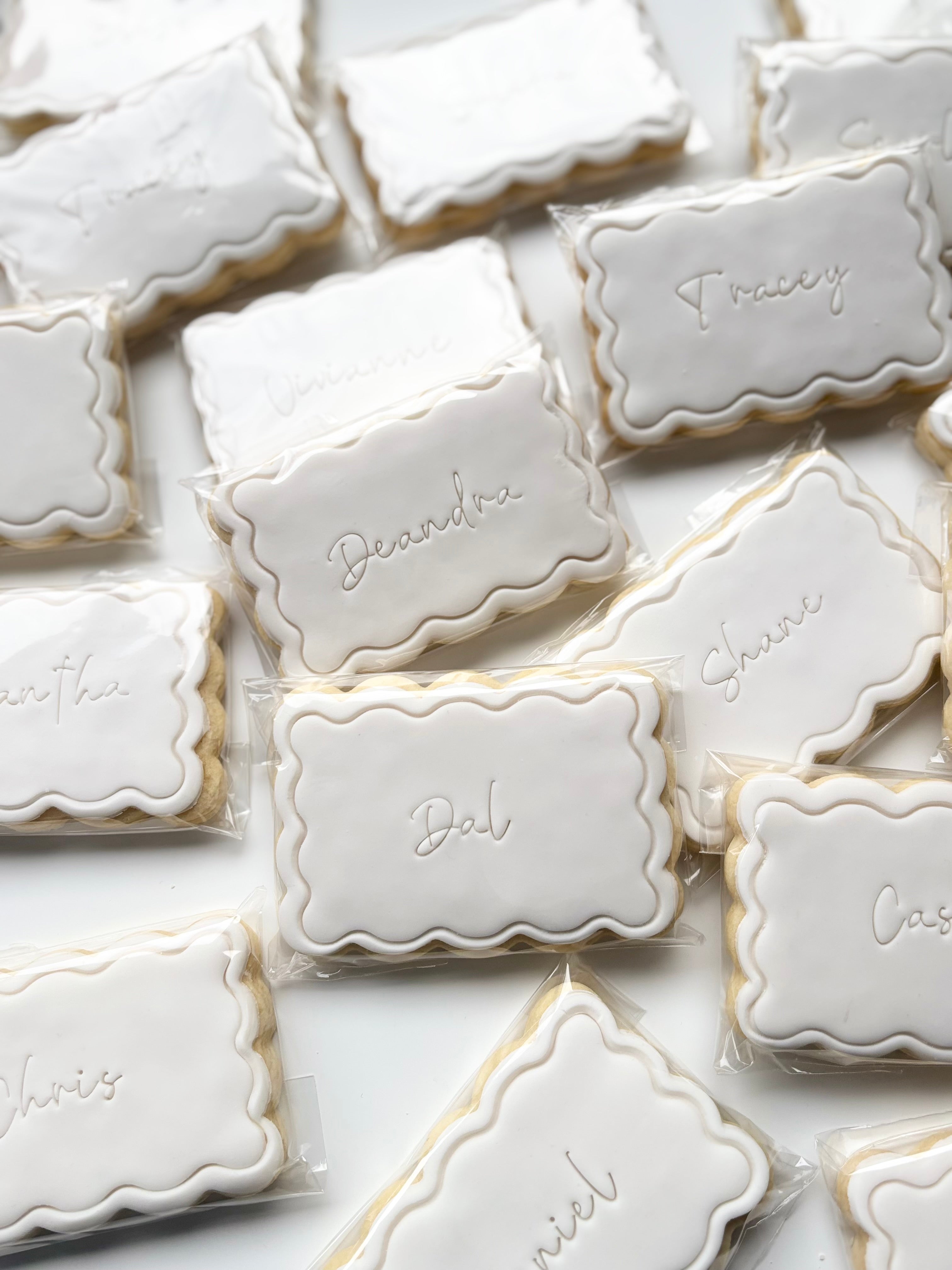 Decorative place-card cookie from My Little Bake Co featuring intricate icing details and personalized design.